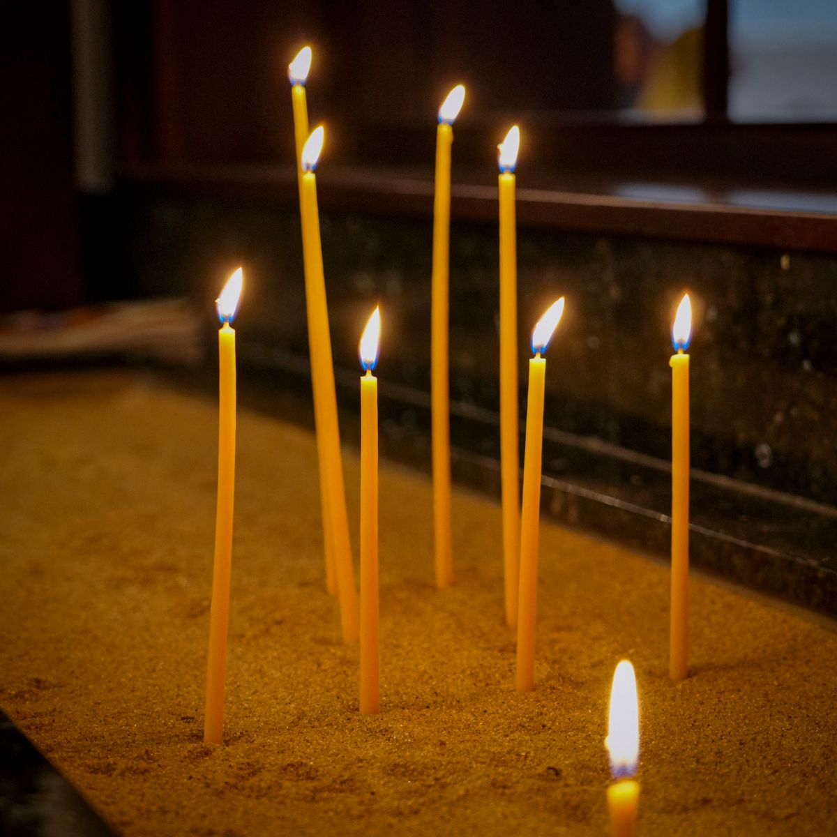 Bougies allumées diffusant une lumière douce dans un espace de recueillement apaisé